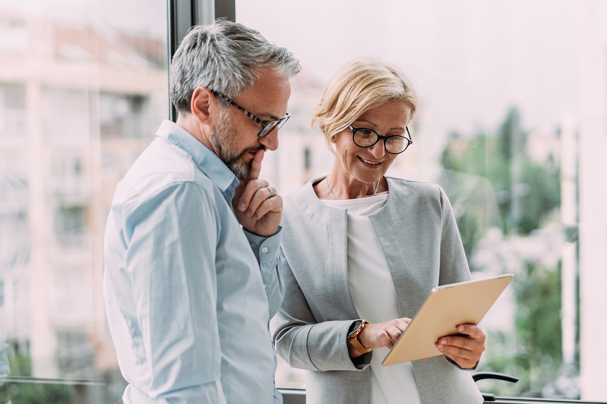 Two people reviewing information on tablet.